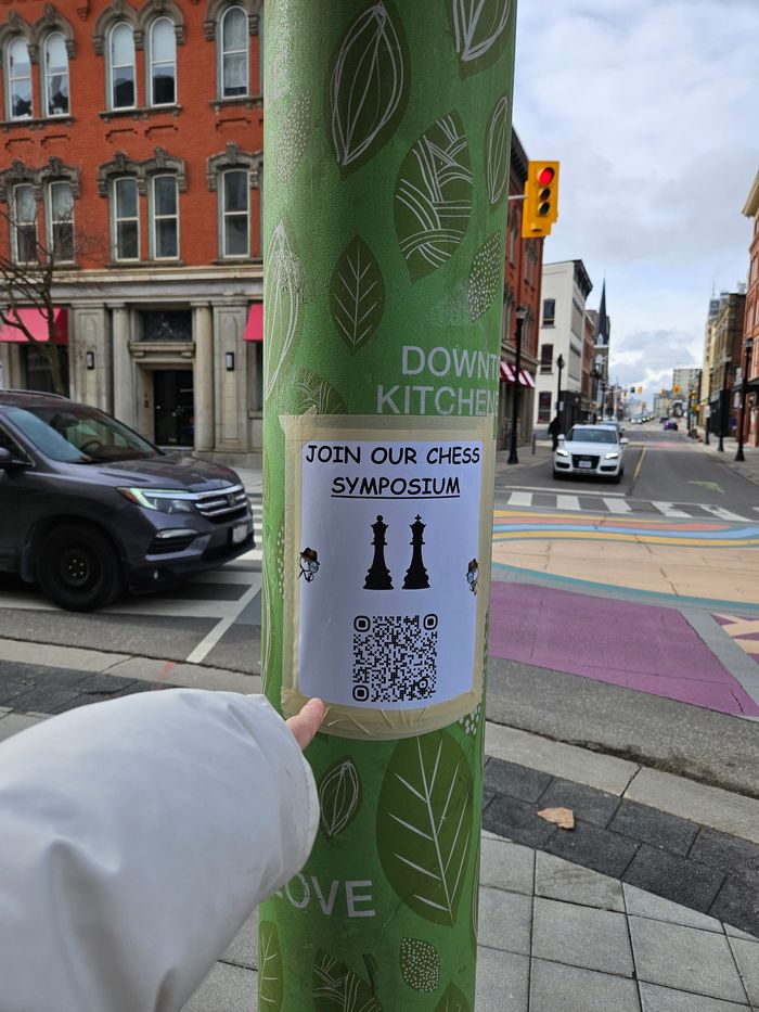 A closeup of one of the posters that we put up on the streetlight poles, with me pointing at it gratuitously.